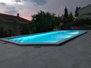a large blue swimming pool in a backyard at REZEVICI BOUTIQUE VILLA in Petrovac na Moru