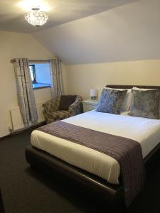 a bedroom with a large bed and a chair at The Cridford Inn in Trusham