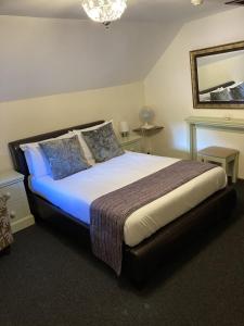 a bedroom with a large bed with blue sheets and pillows at The Cridford Inn in Trusham