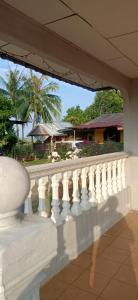 a white balcony with a view of a house at Homestay Damai Sri Kota in Kepala Batas