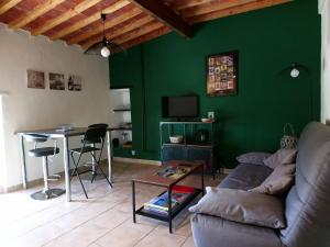 モントゥーにあるGîte Mas de la Restanqueの緑の壁のリビングルーム(ソファ付)