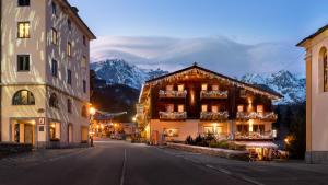 a building on a street with mountains in the background at Locanda Bellevue in Pré-Saint-Didier