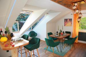a dining room with a table and green chairs at 1001 Nacht Bodensee in Kressbronn am Bodensee