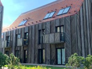 an exterior view of a wooden building with a metal roof at Apartment KOPA in Pervalka