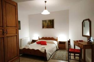 a bedroom with a bed and a table and a mirror at Beautiful and Comfortable House in Vizitsa