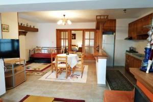 a living room with a table and a kitchen at Beautiful and Comfortable House in Vizitsa