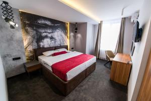 a bedroom with a bed with a red blanket at Hotel Bavka in Leskovac