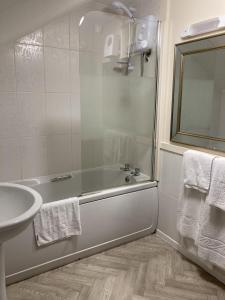 a bathroom with a bath tub and a sink at The Cridford Inn in Trusham