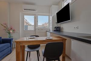 een kleine woonkamer met een tafel en stoelen bij Studio Baarn with patio, airco, pantry, bedroom, bathroom, privacy - Amsterdam, Utrecht in Baarn