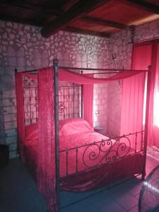 1 dormitorio con 1 cama roja en una habitación de piedra en Castle House, en Cremona