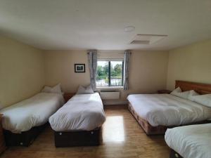 a room with three beds and a window at Waterfront View Apartment in Carrick on Shannon