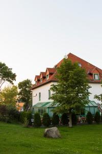 una gran casa blanca con un árbol en el patio en Hotel Landsberg, en Landsberg