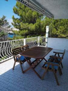 a wooden picnic table and two chairs on a balcony at Apartments Bassi in Stara Baška