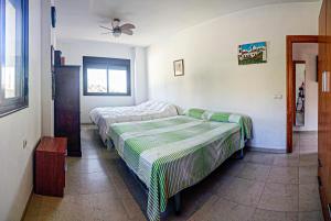 - une chambre avec 2 lits et un ventilateur de plafond dans l'établissement Casa Playa De Guainos, à Adra