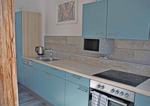 uma cozinha azul com um lavatório e um micro-ondas em Altstadt Ferienwohnung Erfurt em Erfurt