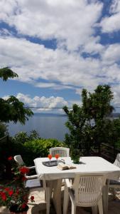 a white table and chairs with a view of the ocean at Apartment Hortenzija in Baška Voda