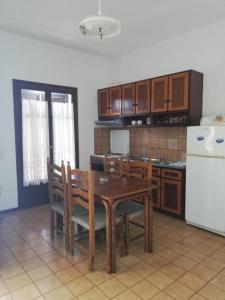 カシオピにあるDimitrakis Apartmentsのキッチン(テーブル、椅子、冷蔵庫付)