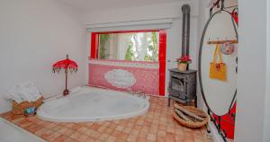 a bathroom with a large tub and a surfboard at Villa Taraça Alaçatı Romantik Otel in Alaçatı