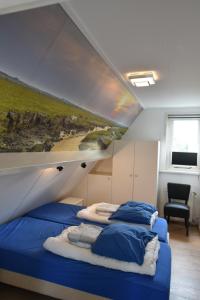 een slaapkamer met 2 bedden en een schilderij aan de muur bij Appartement Tjerk in Hollum