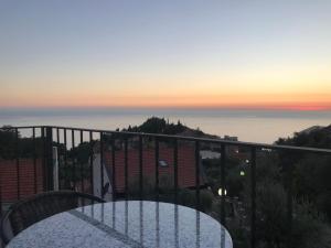 a table on a balcony with a view of the ocean at REZEVICI BOUTIQUE VILLA in Petrovac na Moru