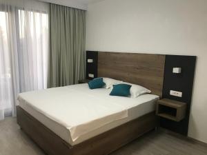 a bedroom with a large bed with a wooden headboard at REZEVICI BOUTIQUE VILLA in Petrovac na Moru