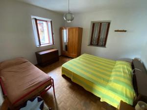 a bedroom with a bed and a chair in it at Appartamenti Nadalini in Levico Terme