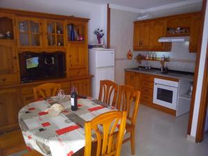 a kitchen with a table with chairs and a white refrigerator at Preciosos atardeceres san marcos in Icod de los Vinos