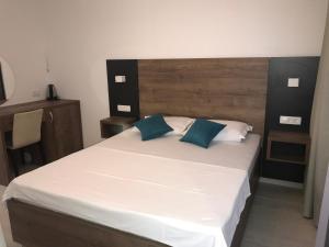 a bedroom with a large bed with white sheets and blue pillows at REZEVICI BOUTIQUE VILLA in Petrovac na Moru