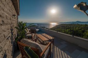 a balcony with chairs and a view of the ocean at Vivid Blue Serenity Resort in Sveti Stefan