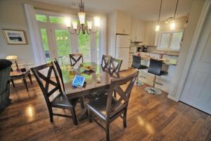 a kitchen and dining room with a table and chairs at Chalet Potvin Bouchard in LʼAnse-Saint-Jean