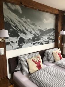 2 Betten in einem Zimmer mit Wandgemälde in der Unterkunft Mountain Lodge Sedrun in Sedrun