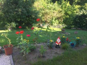 um jardim com flores e uma estatueta na relva em Rekreacny dom pod Bezovcom em Stará Lehota