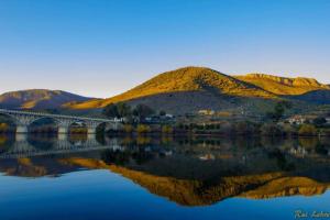 a bridge over a lake with mountains in the background at Residencial Ponto Certo in Vilar Torpim +20 photos