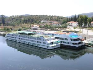 a large building sitting in the water next to at Residencial Ponto Certo in Vilar Torpim