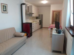 een woonkamer met een bank en een keuken bij Appartamento Cillà in Comano Terme