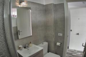 uma casa de banho com um WC, um lavatório e um espelho. em Geremy's boutique vivienda VV A-38-4-2068 em Arona