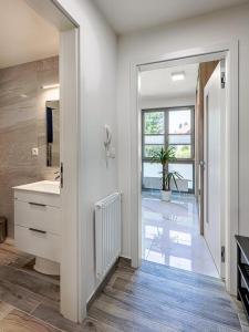 een witte badkamer met een wastafel en een spiegel bij Apartmán A Harrachov in Harrachov