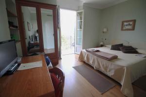 a bedroom with a bed and a table and a television at Relais San Rocco in Sestri Levante