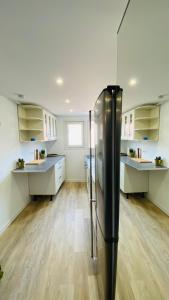 eine große Küche mit einem schwarzen Kühlschrank in der Unterkunft Neuf et cosy à Barr, route des vins in Barr