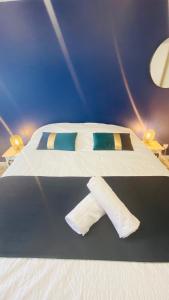 ein Bett mit weißer Bettwäsche und blauen Kissen darauf in der Unterkunft Neuf et cosy à Barr, route des vins in Barr
