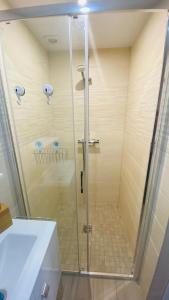 La salle de bains est pourvue d'une douche avec une porte en verre. dans l'établissement Neuf et cosy à Barr, route des vins, à Barr