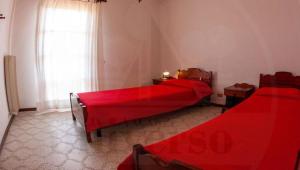 2 camas rojas en una habitación con ventana en VILLA ROSA, en Duna Verde