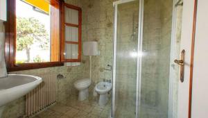 a bathroom with a shower and a toilet and a sink at VILLA ROSA in Duna Verde