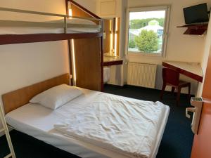 a bedroom with a bunk bed and a desk at Motel 24h Köln in Frechen