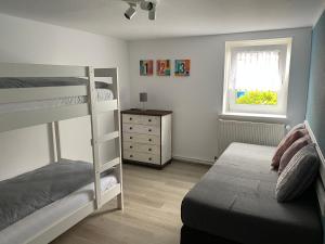 a bedroom with two bunk beds and a window at Ferienwohnung Hohensee EG in Clausthal-Zellerfeld