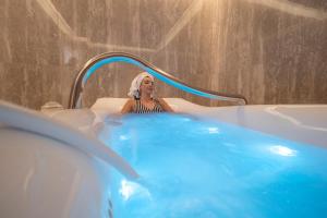 a woman is sitting in a bathtub in a spa at Vivid Blue Serenity Resort in Sveti Stefan