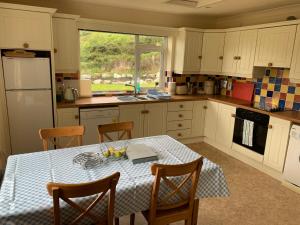 a kitchen with a table with a blue and white table cloth at Errigal Lodge, Dunlewey in Gweedore
