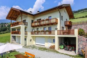 a house with two balconies and a patio at Urlaub auf dem Bauernhof Hallerhof in Villandro