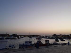 un porto con barche in acqua al tramonto di U dammusu ra cianta a Modica