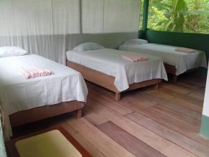 2 łóżka w pokoju z drewnianą podłogą w obiekcie Jungle Explorer Lodge w mieście Mazán